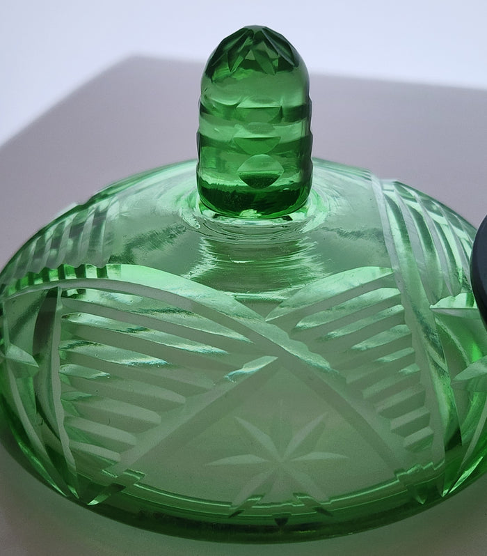 Green covered glass bowl with lid glows