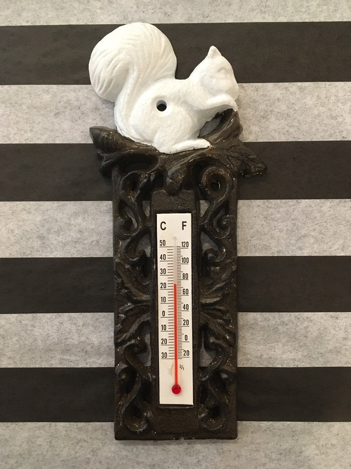A black cast iron thermometer with a white squirrel design on top, featuring a temperature scale in Celsius and Fahrenheit.