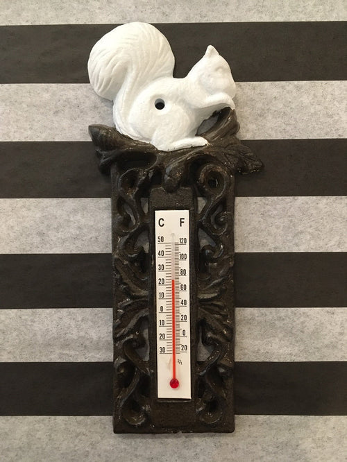 A black cast iron thermometer with a white squirrel design on top, featuring a temperature scale in Celsius and Fahrenheit.
