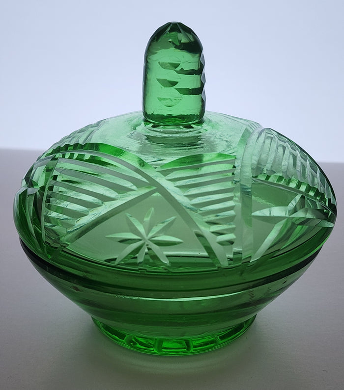 Green covered glass bowl with lid glows