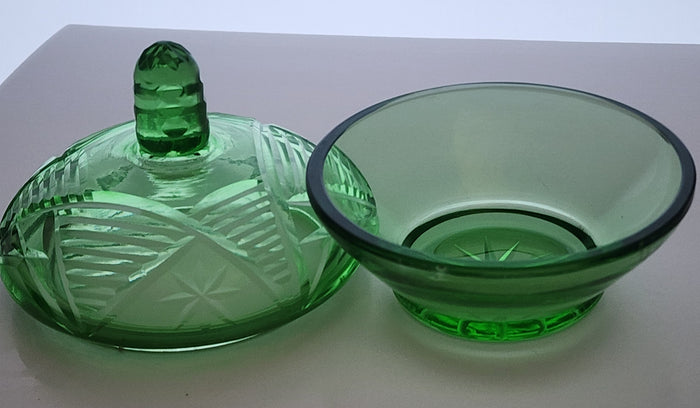 Green covered glass bowl with lid glows
