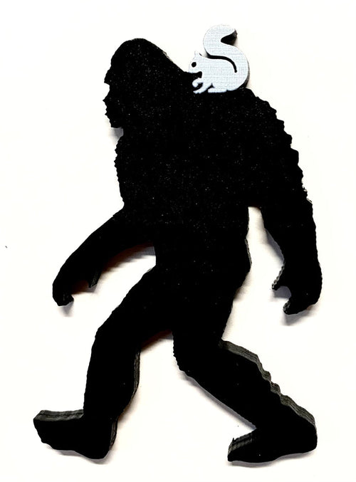A laser-cut magnet featuring a silhouette of Sasquatch with a white squirrel on his shoulder.
